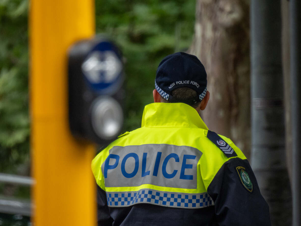 Police officer standing near a residential backyard