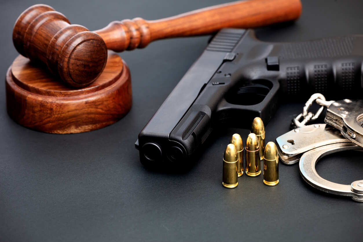 Legal gavel, handgun, bullets, and handcuffs symbolizing Texas Stand Your Ground and Self-Defense laws.
