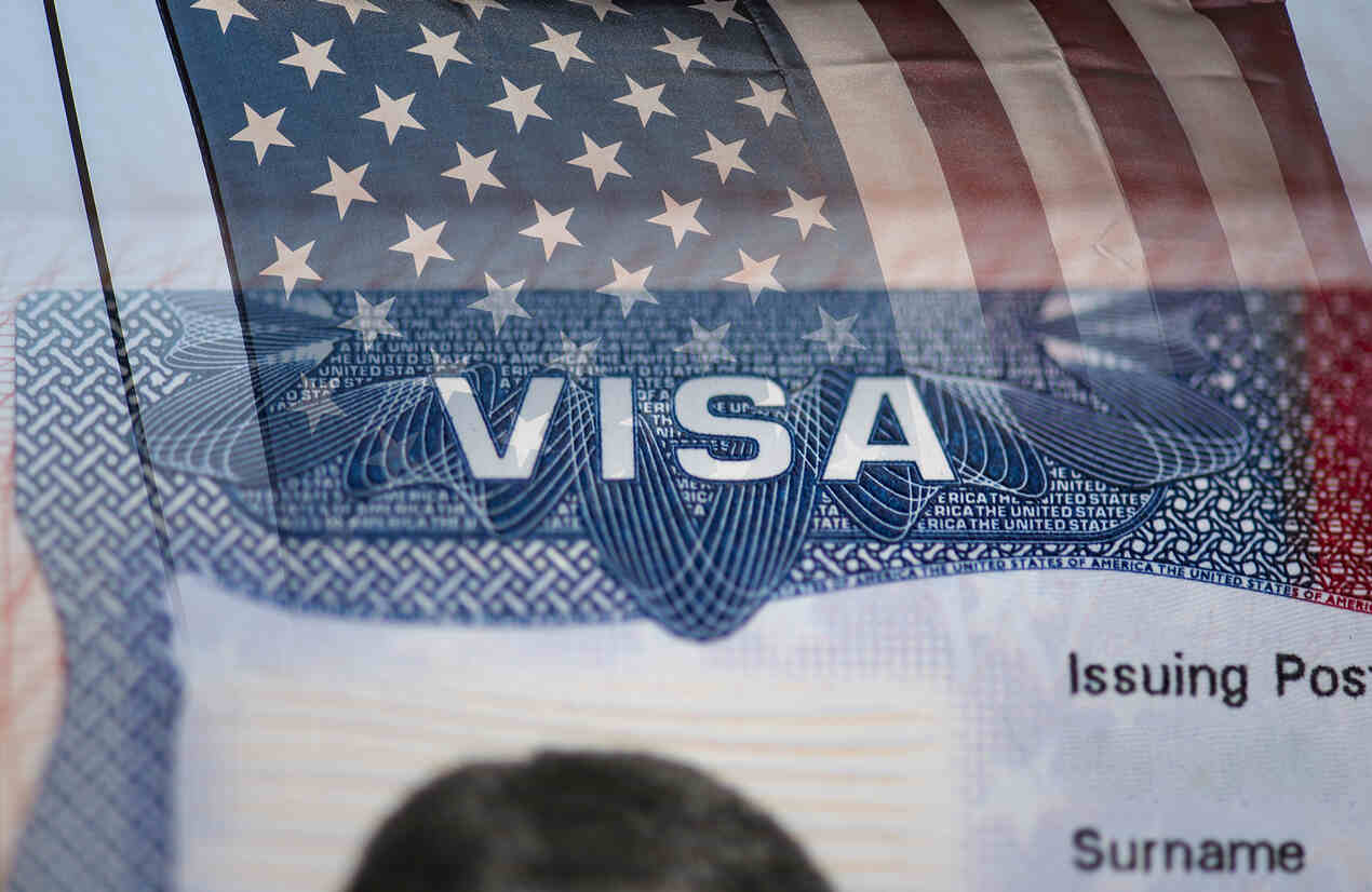 The image features a close-up of a U.S. visa with an American flag overlay.