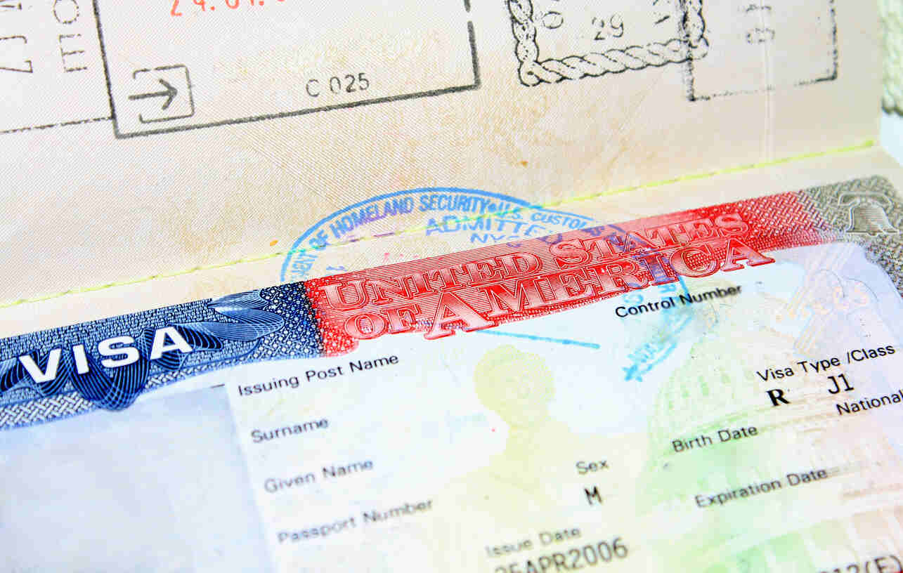 The image shows a close-up of a U.S. J-1 visa in a passport.